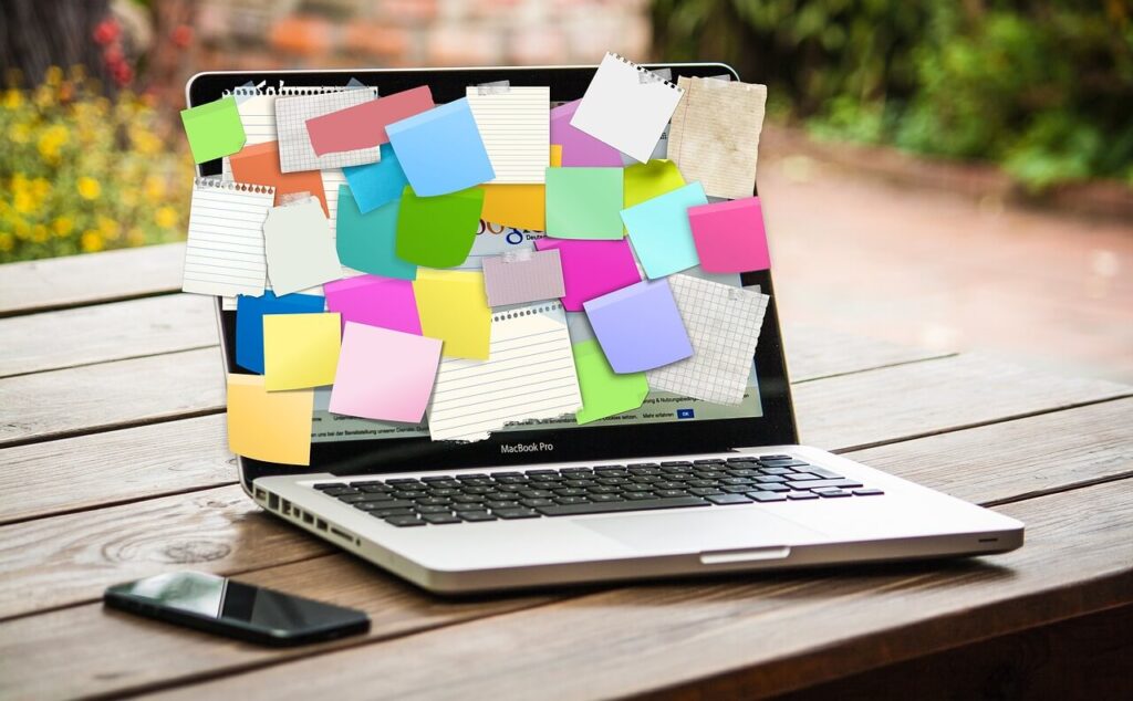 Artículo- laptop con anotaciones con papeles pegado en pantalla - Artículo: 5 estrategias de marketing digital para empendedores